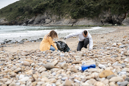 People picking garbage at beach.
