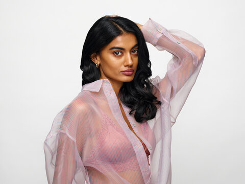 Sexy woman in see through blouse looking at camera