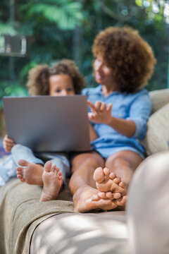 Mom and daughter relaxing while using computer together