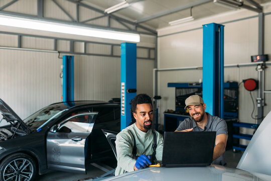 Men Working in Garage, Using Laptop for Diagnostic 