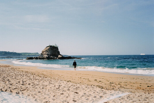 man walking alone on the beach shore
