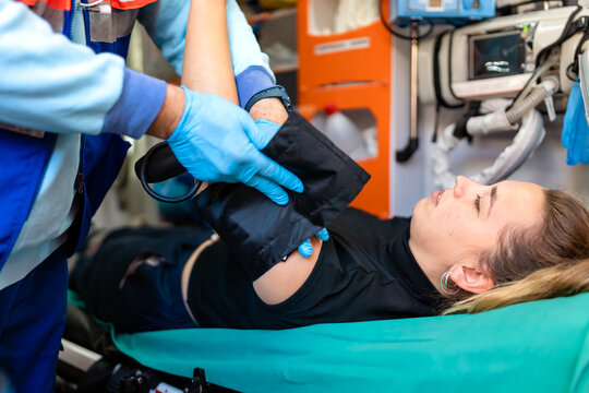 a paramedic taking the blood pressure of a patient in an ambulance.