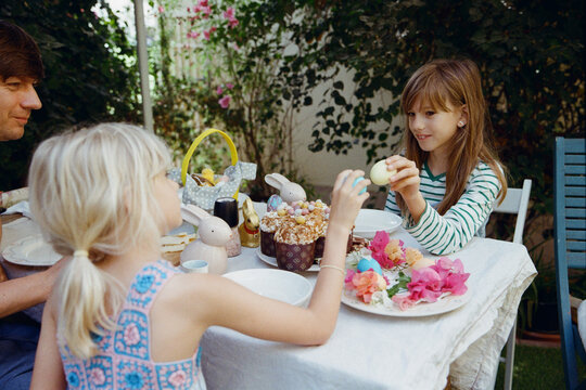 Father with daughters in the garden on Easter