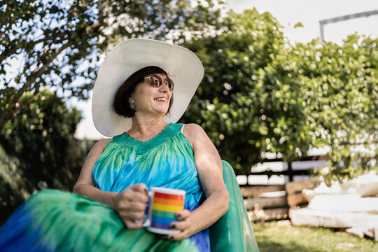 Senior woman having coffee outdoors.