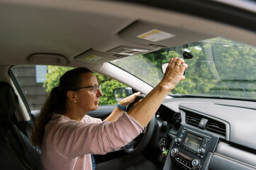 middle aged woman inside a car getting ready to drive somewhere