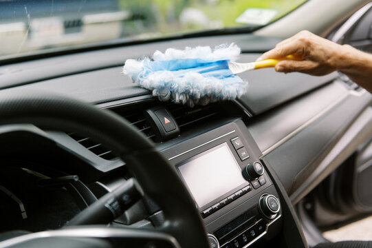 middle aged woman cleaning the interior of her car