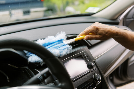 middle aged woman cleaning the interior of her car