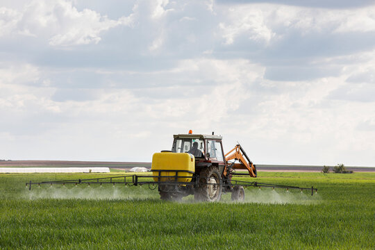 Tractor spraying chemicals to crops