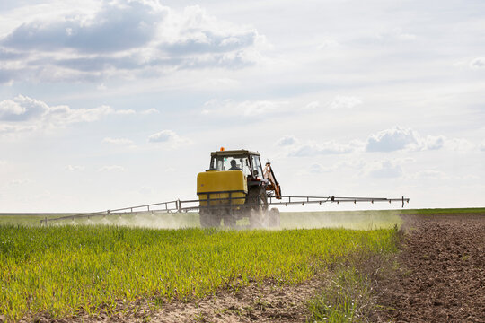 Tractor spraying chemicals to crops