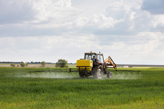 Tractor spraying chemicals to crops