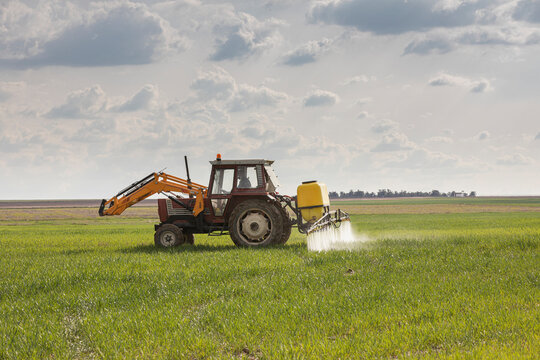 Tractor spraying chemicals to crops