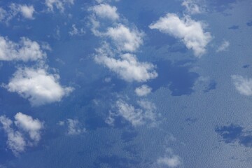white clouds and their shadows on the sea