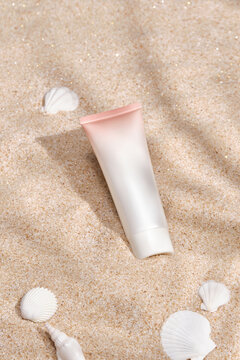 Sunscreen lotion on sandy beach as background