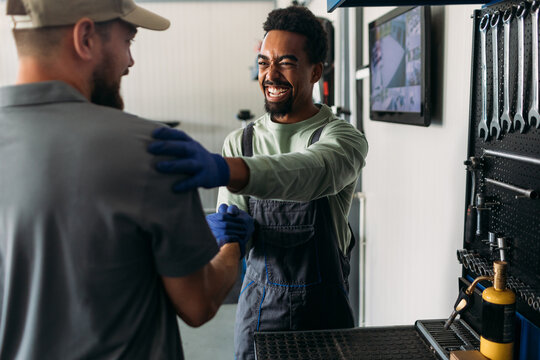 Two Workers in Car Garage 