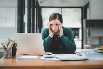 Tired businesswoman sleepy and bored from sitting at a desk for a long time and has office syndrome