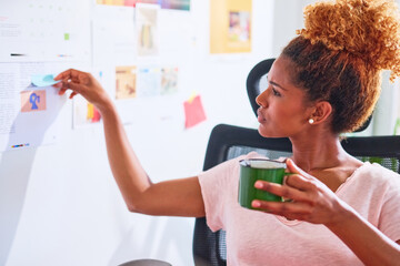 Businesswoman read note on wall.