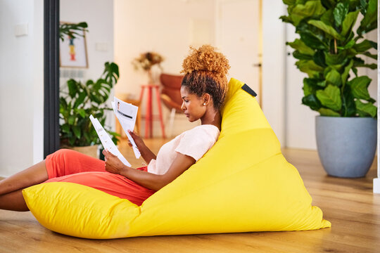 Freelance woman reads resumes at home.
