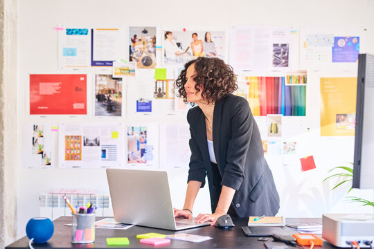 Businesswoman stand at desk in office.