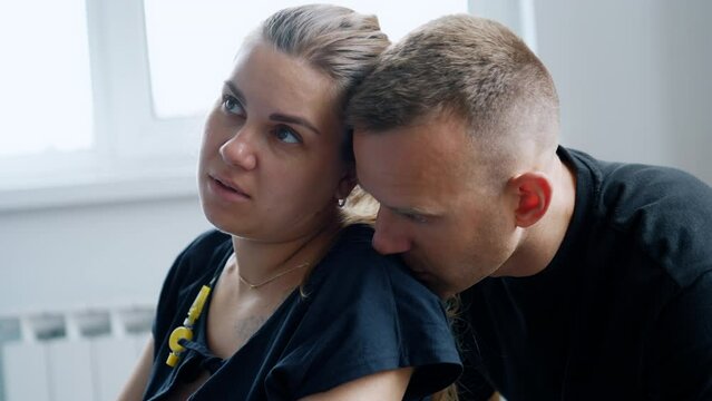 Child Delivery Process. Woman Sits Calm During The Break Between Contractions. Husband Sits Behind Kissing Her On The Shoulder. Close Up.