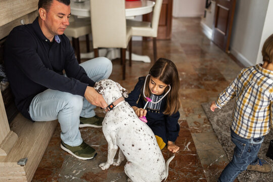 father with his children and dog at home playing with them