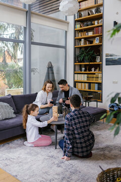 Immediate family childhood gathering living room board game home 
