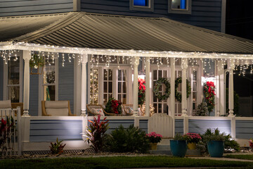 Brightly illuminated christmas decorations on front yard porch of florida family home. Outside...