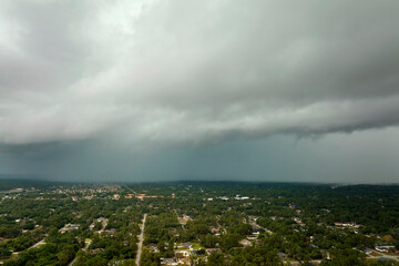 Landscape of dark ominous clouds forming on stormy sky before heavy thunderstorm over rural town...