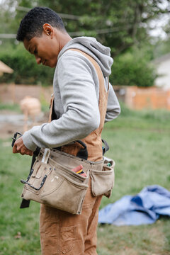 Capenter putting on her toolbelt before work.