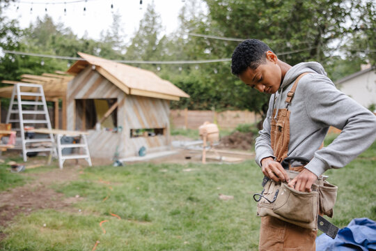 Capenter putting on her toolbelt before work