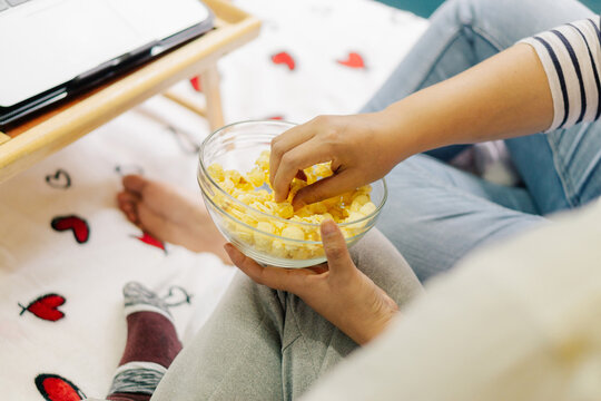 Close-up of a bowl of popcorn and a laptop.