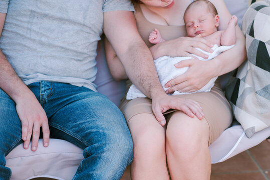 Serene Family Moment: Young Couple Resting on Bench with Their Baby.