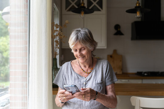 happy Senior woman at home using phone