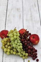 Apples and grapes on a white wooden table, free space, place for text, background image for presentations, background, summer