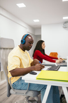 Man with headphones listening to music while working in the office