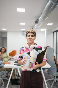 Portrait of a young business non-binary person in a workspace