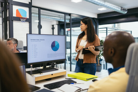Female boss talking to the workers of her company in a modern office