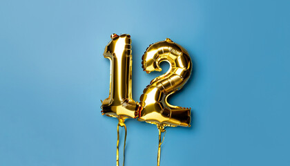 Fototapeta na wymiar Banner with number 12 golden balloon with copy space. Twelve years anniversary celebration concept on a blue background.
