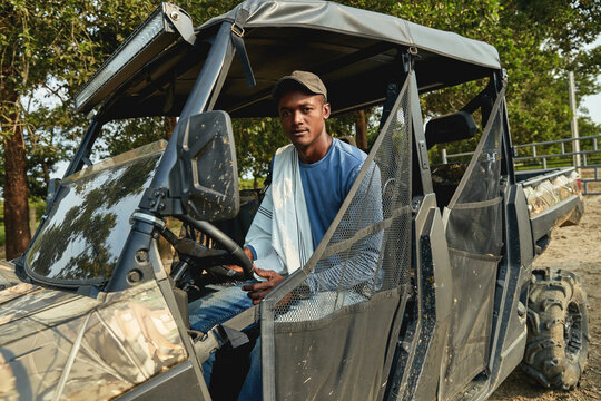 A young farmer resting next to a buggy car in a Colombian farm.