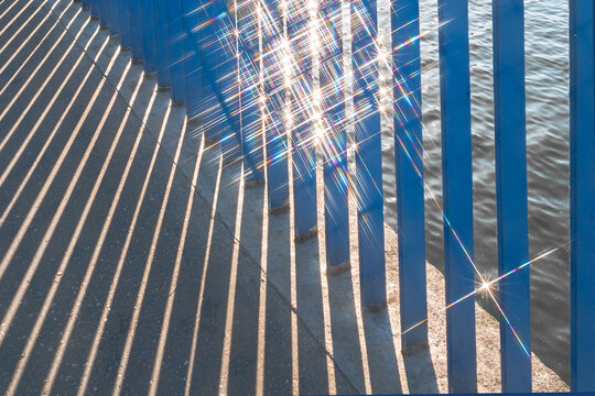A conceptual photo with strips of railing and a glint of water