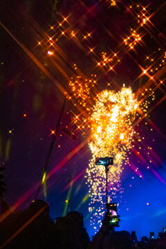 A night show with fireworks and a crowd of people with smartphones