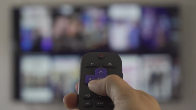 Using the remote control to change the channel on a streaming platform the television is blurred out. SHOTLISTstream.