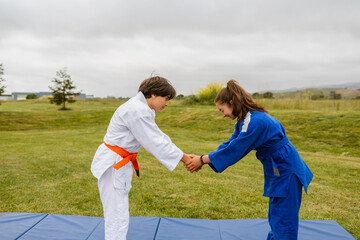 Judokas couple formal greeting in nature