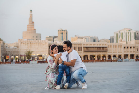 Loving Indian family embracing on city square