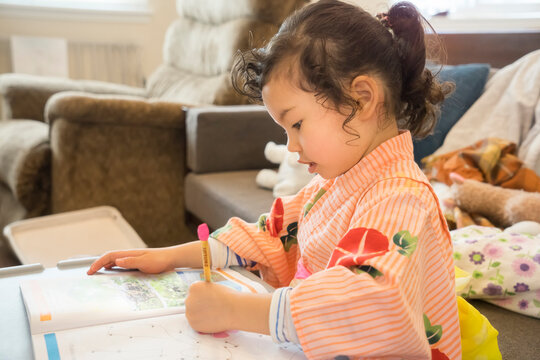 Japanese little girl in kimono studying at home