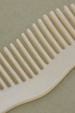 Macro of Curvy Cream-Colored Comb on Sage Surface
