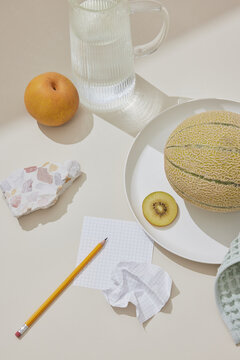 Tranquil Still Life: Water, Fruit, and Terrazzo on Beige Surface