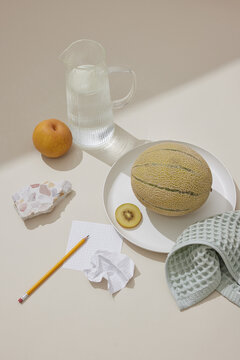 Tranquil Still Life: Water, Fruit, and Terrazzo on Beige Surface