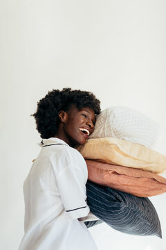 Woman in Pajamas Holding Pillows and Laughing