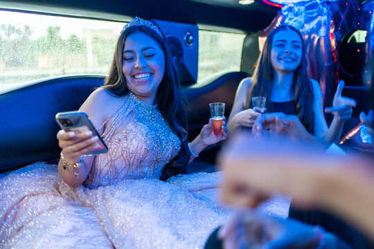 Quinceanera With Friends On Her 15th Birthday Party In A Limousine. 