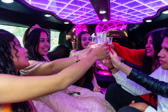 Quinceanera Toasting With Friends On Her Birthday In A Limousine. 